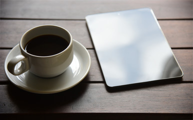 mock up tablet blank screen and coffee cup on the desk in interior at home office,space for your text.