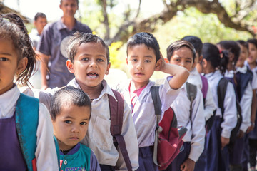 Rural Indian village school children standing outside class for morning prayer.