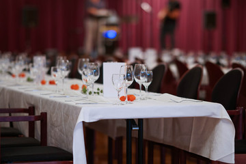 Decorated table on a gala dinner party with wine glasses and blurred out background