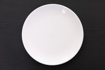 黒い木製テーブルに置かれた白い皿