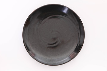 白いテーブルに置かれた黒い皿