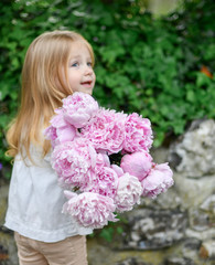 Blonde girl holding fresh peonies bouquet