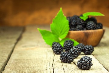 Fresh blackberries in a wooden bowl. Healthy forest fruits. Sales of blackberries. Healthy food.