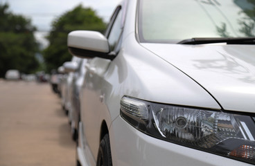 Closeup of front side of white car park in parking area in sunny day. 