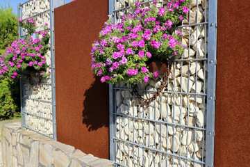 Fototapeta na wymiar Gabione mit Sichtschutzelementen und Blumen