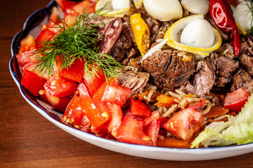 Traditional Uzbek oriental cuisine. Samarkand pilaf from mutton with vegetables, to a company of several people in a restaurant. background image. Copy space, selective focus
