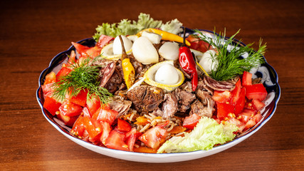 Traditional Uzbek oriental cuisine. Samarkand pilaf from mutton with vegetables, to a company of several people in a restaurant. background image. Copy space, selective focus