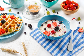 Photo of Viennese waffles, oatmeal, coffee, fresh raspberries, strawberries, gooseberries
