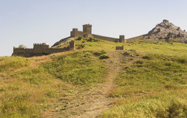 Fototapeta na wymiar An ancient defensive fortress on a hill overgrown with green grass.Crimea.