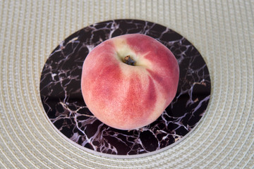 Ripe delicious peach fruit on a light wicker cloth