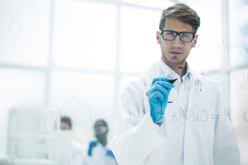 scientist making notes on the glass Board at the time of the experiment
