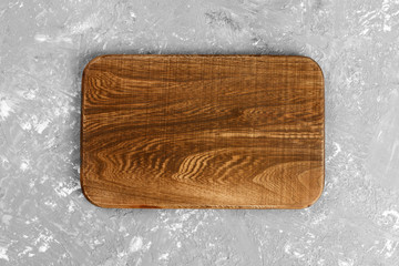 dark handmade wooden cutting board on dark background. Top view