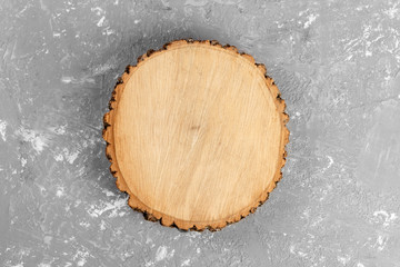Tree stump round cut with annual rings on cement background. top view with copy space