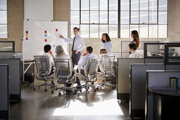 Young male manager using whiteboard in a business meeting