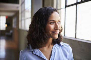Smiling young mixed race businesswoman looking away