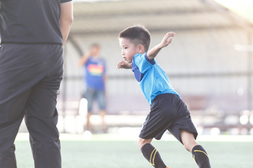 Young Asian football player in blue jersey between competition.