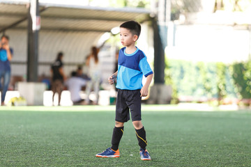 Young Asian football player in blue jersey between competition.