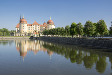 Fototapeta na wymiar Castle Moritzburg in Saxony near Dresden in Germany surrounded by pond, reflection blue lake, blue sky