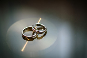 Wedding rings on a table and a light reflection