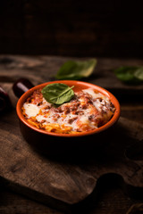 Traditional lasagne in a casserole dish on wooden table