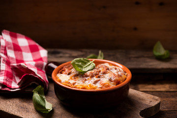 Traditional lasagne in a casserole dish on wooden table