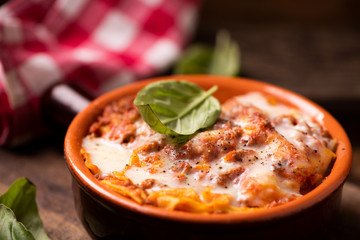 Traditional lasagne in a casserole dish on wooden table