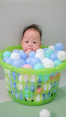 Fototapeta na wymiar Asian baby is in the ball basket.