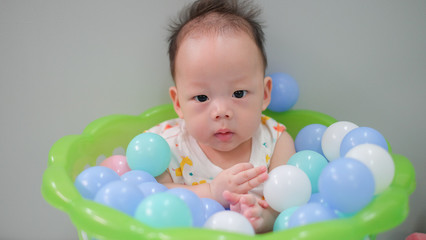 Fototapeta na wymiar Asian baby is in the ball basket.
