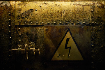 Sign of high voltage, glued on a rusty metalic background with rivets.