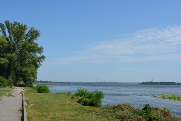 Сity landscape with green trees on the left bank of the city, river and new houses on the second...