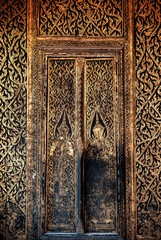 Ancient grunge old gold painted Thai wood door of Wat Ratchaorotsaram  Bangkok