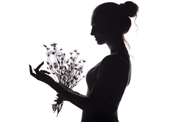 silhouette profile of a beautiful girl with a bouquet of dried flowers on a white isolated background