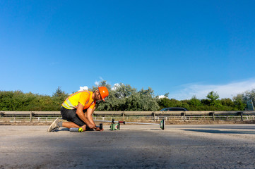Worker or builder (Surveyor) with GPS on construction site during the sunny day with blue sky in...
