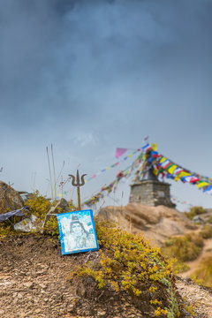 Photo of Lord Shiva on the ground with a stupa in the background at Annapurna Base Camp, Nepal.