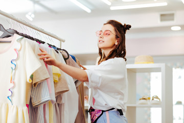 Nice hairstyle. Modern beautiful woman with nice hairstyle looking for new outfit while coming to shopping mall