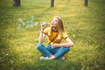 Young woman are blowing soap bubbles outdoors