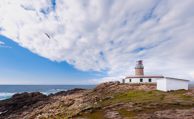 Fototapeta na wymiar Marine landscape with lighthouse,sea,cliff and cloudy sky. Galizia, Spain.