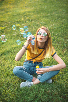 Young woman are blowing soap bubbles outdoors