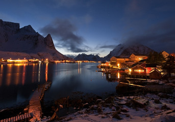 A night view of Reine village and Reinefjord, with the mountains of Navaren and Olstind in the background