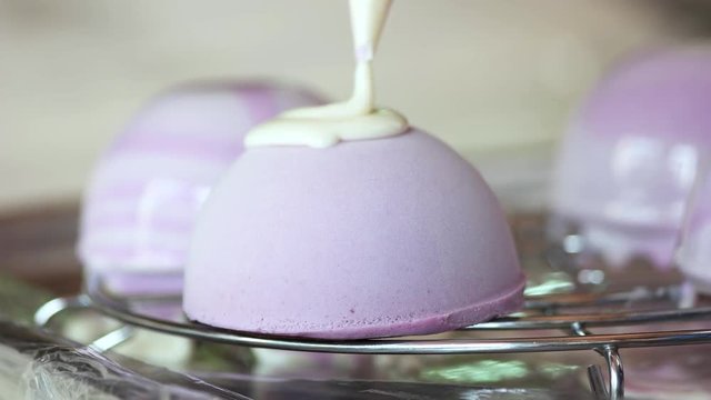 Pouring mousse cake with mirror glaze. Glazing french dessert at confectionery. Mirror glaze tutorial.