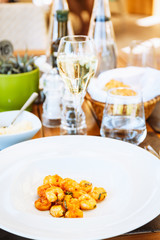 Shrimps in tomato sause at the table. Outdoor Italian restaurant terrace. Concept of summer authentic meal