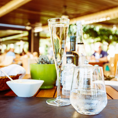 Wine and water at the table. Outdoor Italian restaurant terrace. Concept of summer authentic meal