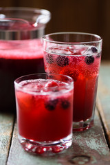 Refreshing non alcoholic beverage. Sangria, cold drink of cherry juice and soda with ice on blue background