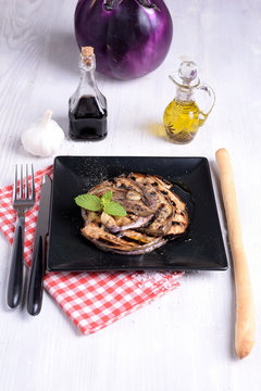 Plate of roasted aubergines flavored with vinegar and mint oil 