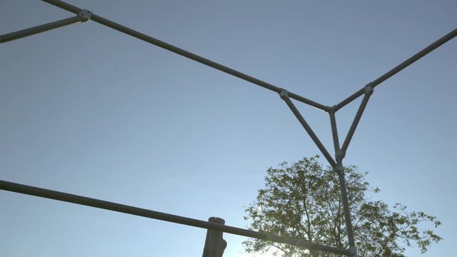 A young man doing parkour jumps through an opening in the scaffolding and continues running.
