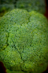 Big and ripe broccoli florets on wooden table.