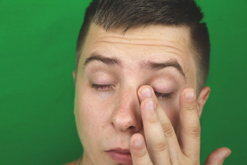 Obraz premium Tears in eyes of crying adult man. Green background. Chromakey