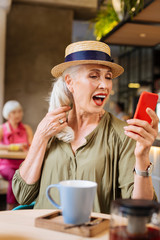 I am beautiful. Attractive mature woman touching her hair while looking at herself in the camera