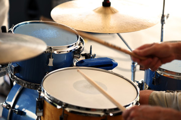 A closeup of a drummer playing a drum set.
