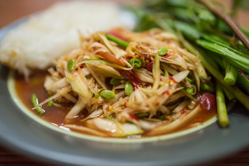 Somtum, papaya salad, famous Thai food close up with stricky rice
